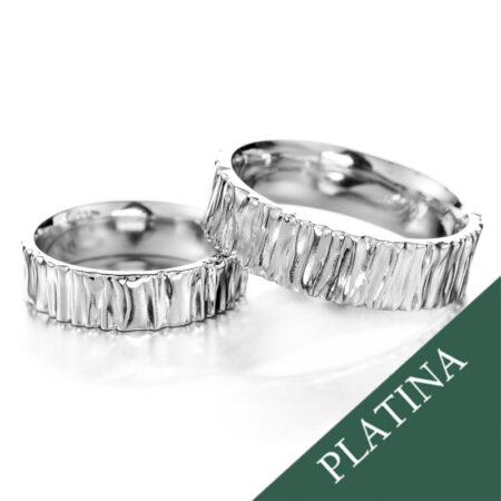 Kaksi Kaarna-platina-kihlasormusta voimakkaasti kuvioidulla pinnalla